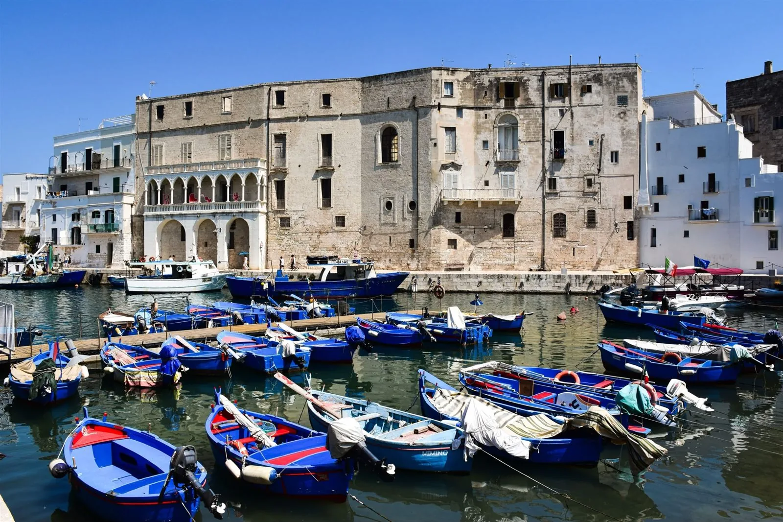 Barche azzurre dei pescatori sotto le mura di Monopoli